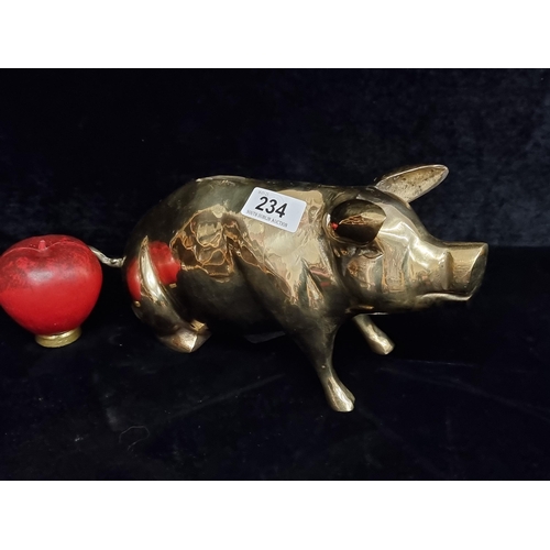 234 - A heavy brass money box in the form of a seated pig.