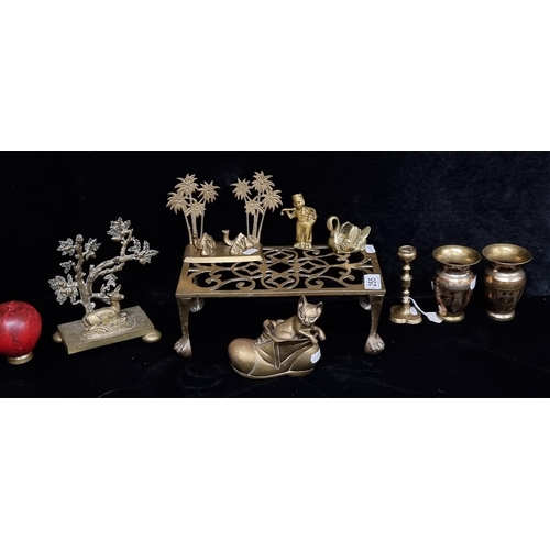 255 - A mixed lot of brass items comprising of a large trivet stand and a pair of urn shaped bud vases.