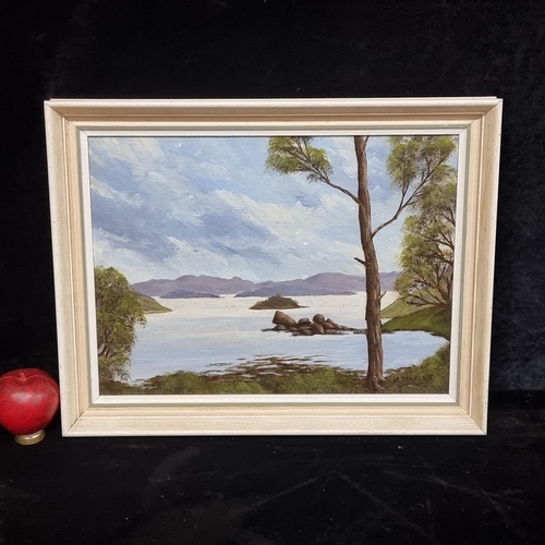 82 - An original oil on board painting featuring a lakeside landscape scene with blue grey mountains to d... 