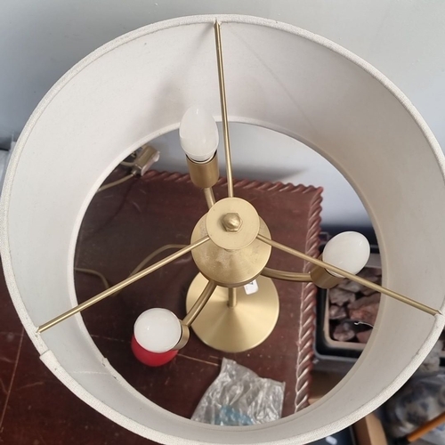 427 - Modern brass table lamp with three-bulb fixture and cream fabric drum shade.