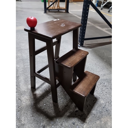 405 - Convertible wooden step stool/table, made from dark-stained wood, featuring a fold-out two-step desi... 