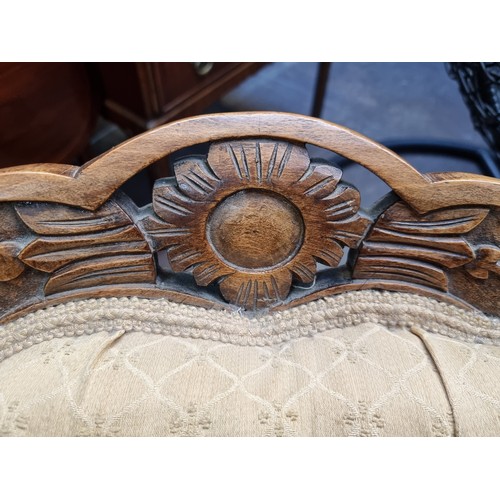 367 - An antique nursing chair featuring a carved oak wood frame, button back with braiding mounted on cas... 