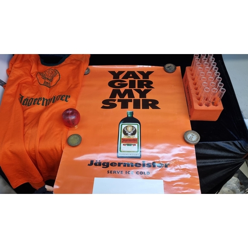 141 - A box containing Jägermeister memorabilia including a poster and shot test tubes and a t shirt.