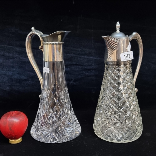 142 - A lovely pair of cut glass claret jugs with silver plated handles and tops.