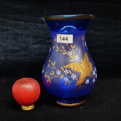 144 - A beautiful cobalt blue glass vase adorned with gilt bird motif.