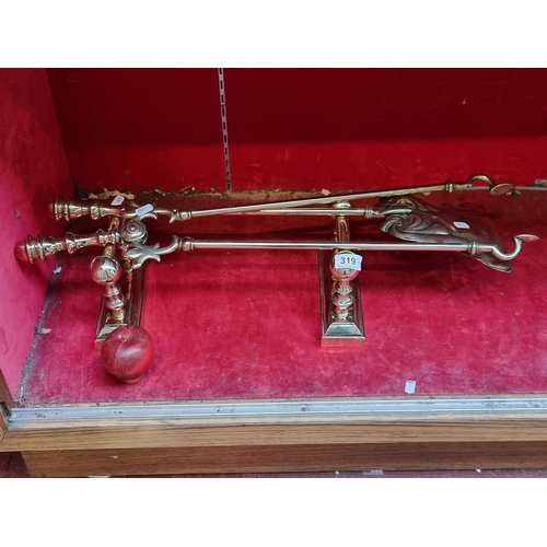 319 - A very handsome vintage brass fireside items including a pair of fire dogs, shovel and tongs. (4) in... 