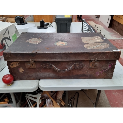 336 - An antique leather suit case with original decals. Vintage luggage.