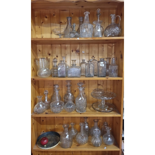 375 - Four full shelves of antique and vintage glass decanters and apothecary bottles. Some lovely example... 