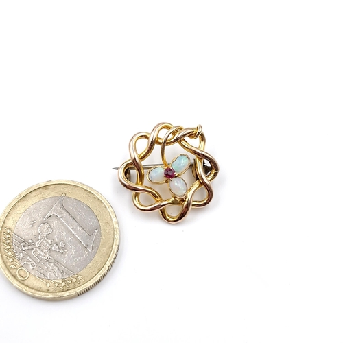 45 - A delicate opal & ruby brooch set in nine carat gold. Weight - 2 grams.