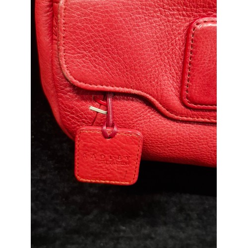 260 - A fashionable Radley bright red leather hand bag. With the iconic Scottie dog tag.