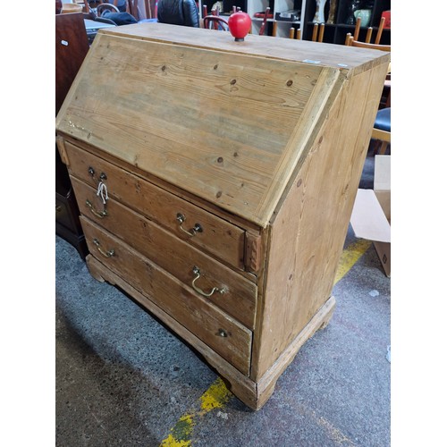 424 - Star Lot : An antique pine writing desk with three drawers, brass drop leaf handles, top section fea... 