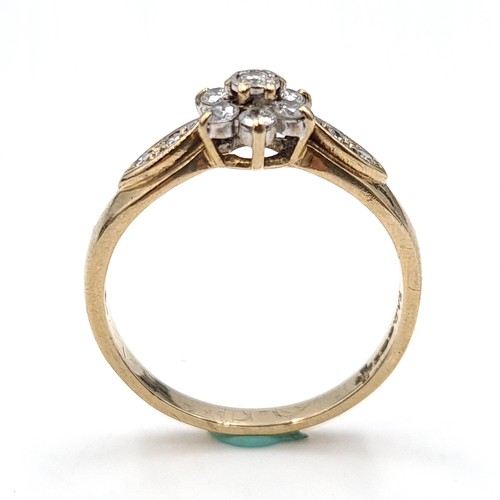 28 - Star Lot : An attractive daisy diamond ring with diamond shoulders set in nine carat gold. 'DIA' mar... 