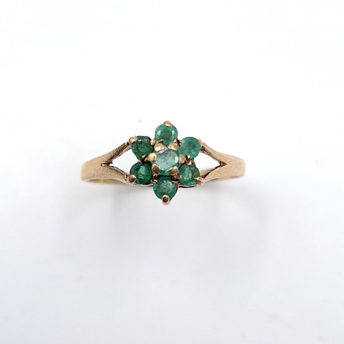 29 - A pretty emerald daisy cluster ring set in nine carat gold (375). Ring size - P. Weight - 1.58 grams... 