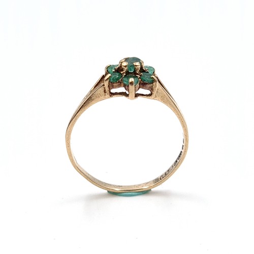 29 - A pretty emerald daisy cluster ring set in nine carat gold (375). Ring size - P. Weight - 1.58 grams... 