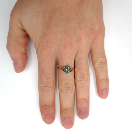 29 - A pretty emerald daisy cluster ring set in nine carat gold (375). Ring size - P. Weight - 1.58 grams... 