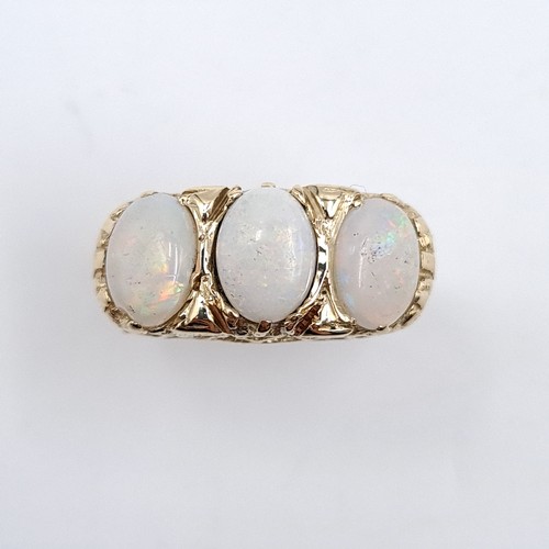 39 - Star Lot : A nine carat gold vintage three stone opal ring. Size - L 1/2. Weight - 2.99 grams.