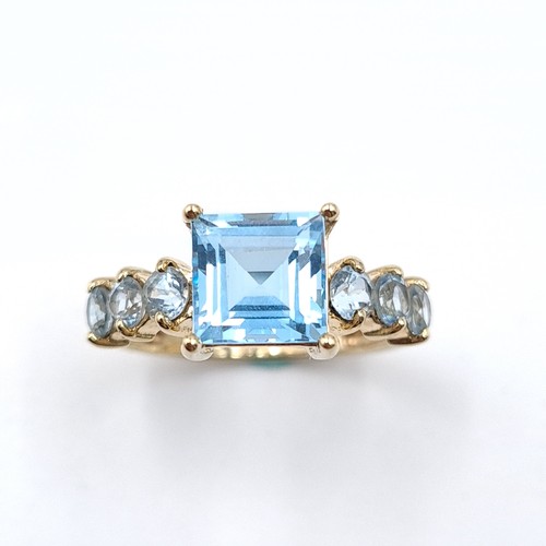 44 - A very pretty  example of a blue topaz seven stone ing set with topaz shoulders set in nine carat go... 