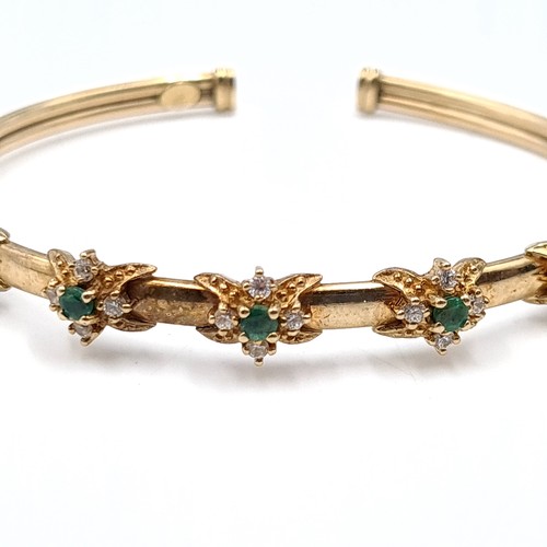 501 - Star Lot : A nine carat gold emerald and gemstone bangles with 375 stamped to band. Weight - 9.23 gr... 