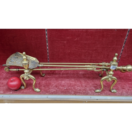 318 - An antique  set of solid brass fire irons and fire dogs. Includes shovel, tongs and a poker. Very go... 