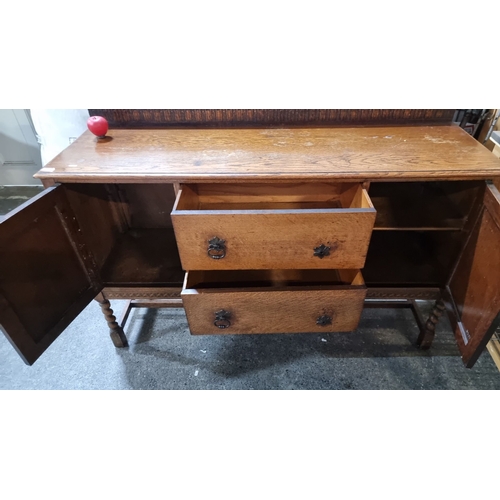 592 - An early 20th Century oak sideboard with carved details, two central drawers and side cupboards.