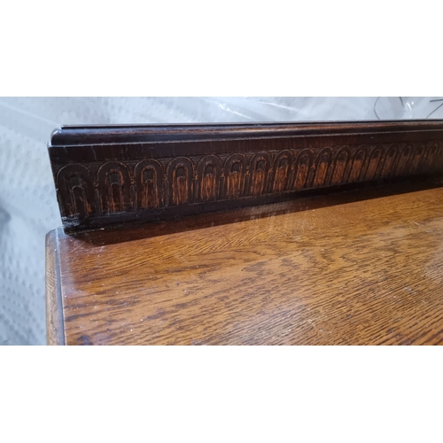 592 - An early 20th Century oak sideboard with carved details, two central drawers and side cupboards.