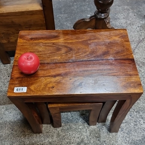 611 - A solid hardwood nesting table set features a warm, polished finish with natural grain details.