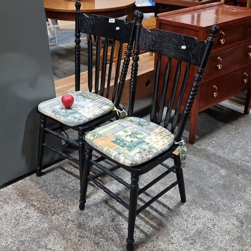 616 - A pair of vintage spindle-back wooden chairs, ebonized finish, adorned with patterned tie-on cushion... 