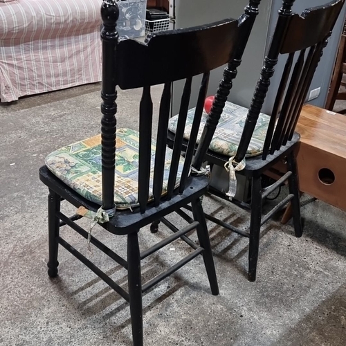 616 - A pair of vintage spindle-back wooden chairs, ebonized finish, adorned with patterned tie-on cushion... 