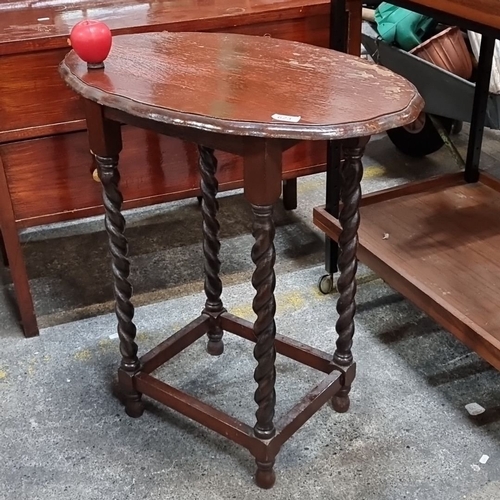 623 - An Early 20th-century oak side table with barley twist legs, scalloped oval top, and stretcher base.... 