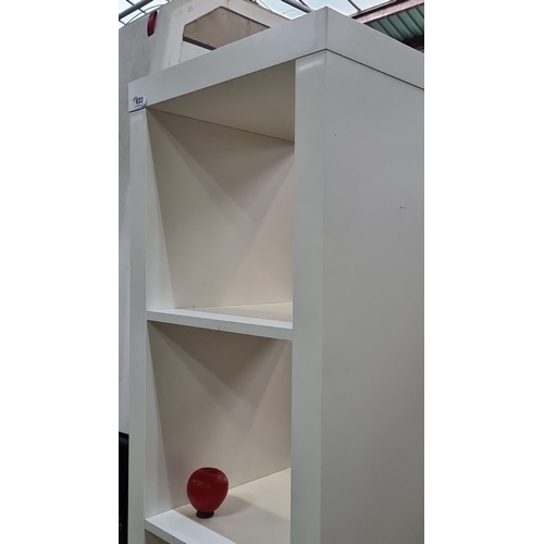 633 - A tall, contemporary white freestanding shelving unit with five adjustable shelves. Constructed from... 