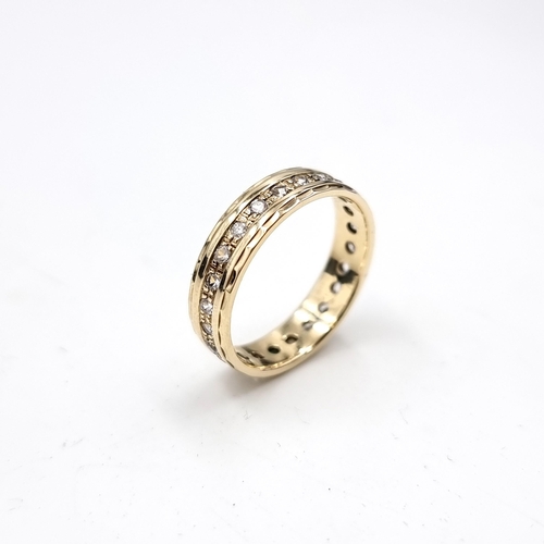 15 - A nine carat gold full eternity gem set ring. Size - N. Weight - 2.8 grams. Boxed.