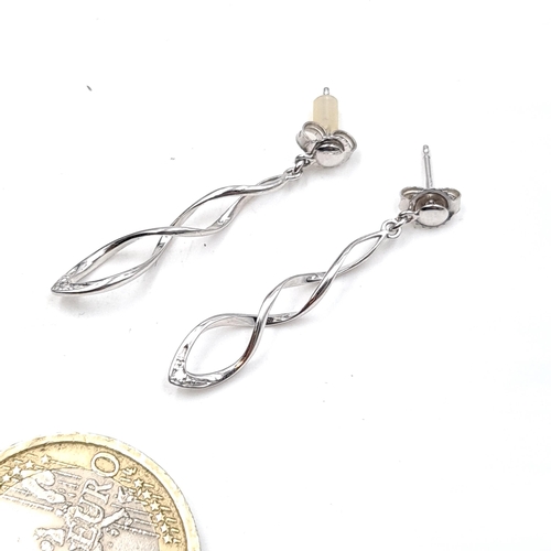 585 - A pair of nine cart white gold drop stud earrings. Hallmarked to posts. Weight - 1.2 grams.