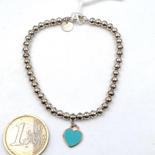 667 - A Tiffany turquoise heart charm bracelet marked Tiffany. Comes in a Tiffany pouch.