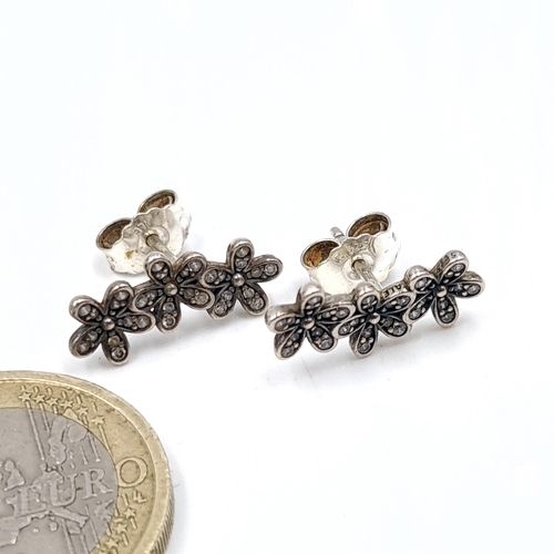 668 - A pair of sterling silver stud earrings of floral design. Boxed.