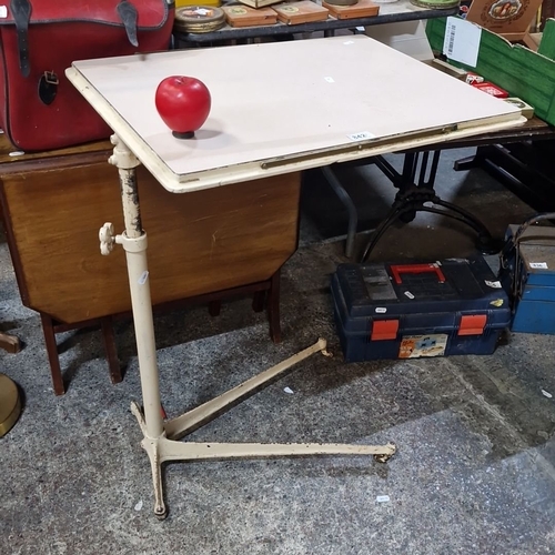 842 - A Vintage adjustable metal drafting table with cream enamel finish and a tilting top.