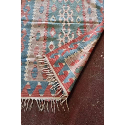 677 - Handwoven kilim rug with geometric tribal patterns in vibrant pastel tones, fringed edges, from the ... 