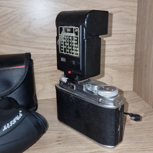 882 - Includes Agfa camera with Hanimex X215 flash, black leather case and a pair of compact binoculars.