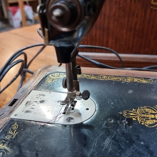 891 - Vintage Singer Sewing Machine with Wooden Case, from the 1940s. Hand-crank model featuring ornate go... 