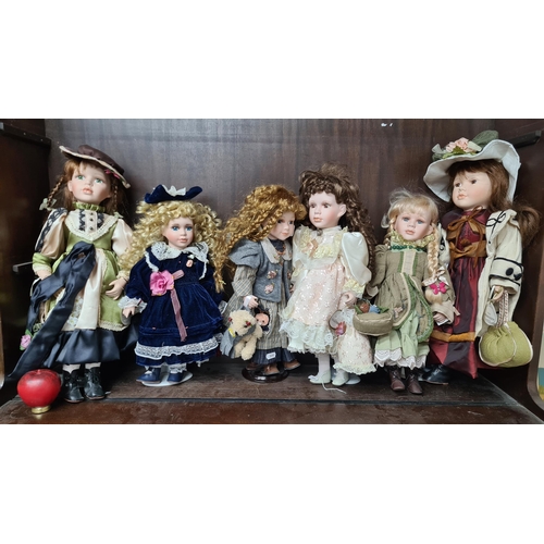 714 - Five vintage porcelain dolls with intricately designed outfits.