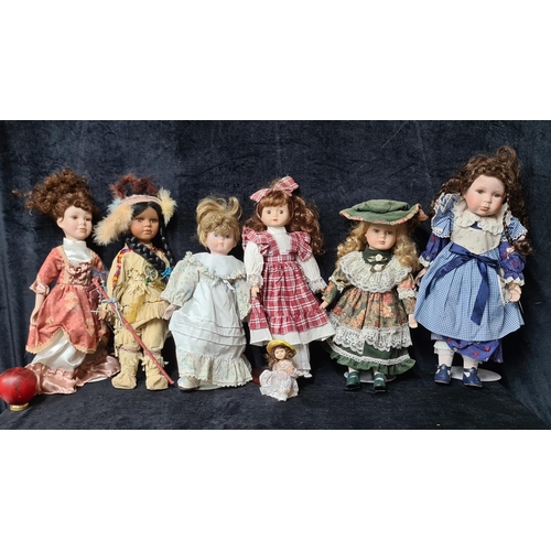 733 - Six vintage porcelain dolls with intricately designed outfits.