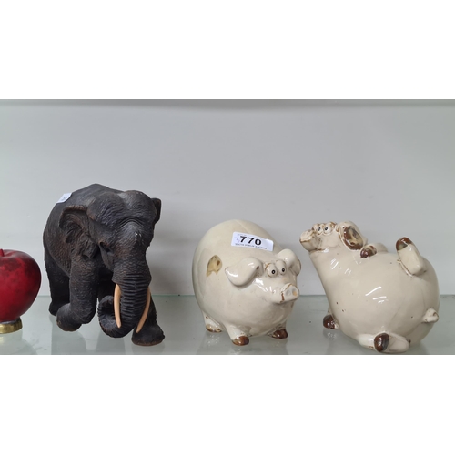 770 - A humorous pair of ceramic pig figures, along with a carved wooden figure of an elephant.