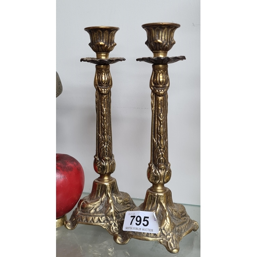 795 - A pair of antique brass candlesticks.