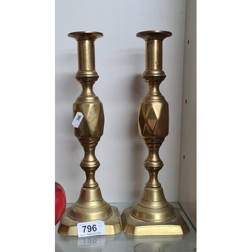 796 - A pair of antique style brass toned candlesticks.