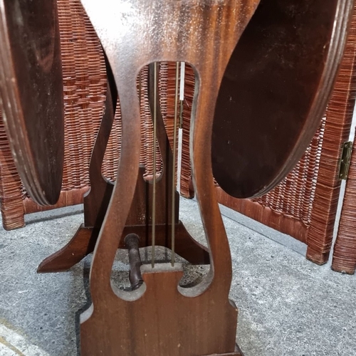 970 - Victorian mahogany drop-leaf table with leather-inlaid top, lyre-shaped supports, and stretcher base... 