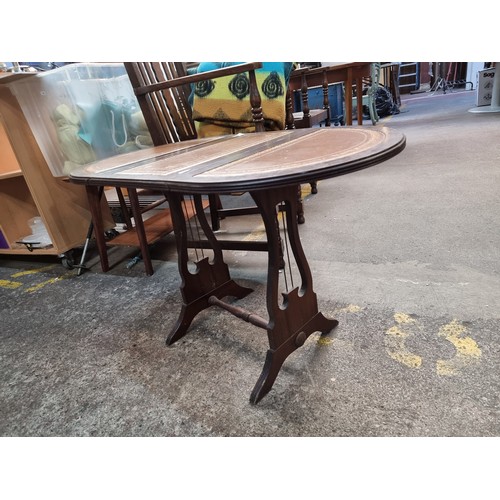 970 - Victorian mahogany drop-leaf table with leather-inlaid top, lyre-shaped supports, and stretcher base... 