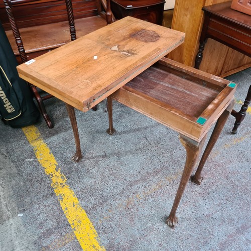 444 - An antique card games table with lion paw feet, original green baize and swivel top opening to revea... 