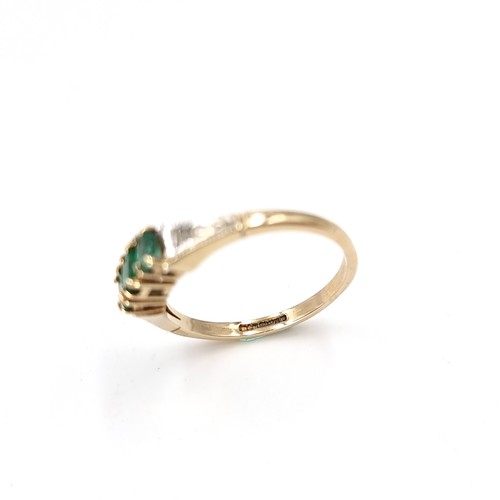 24 - Star Lot : A three stone nine carat gold 375 emerald ring with diamond set shoulders. Ring size - O.... 