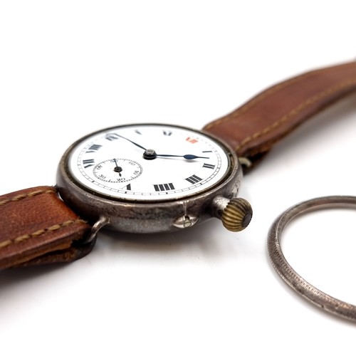 530 - An antique military wristwatch with leather strap. Item in need of attention - face without glass at... 