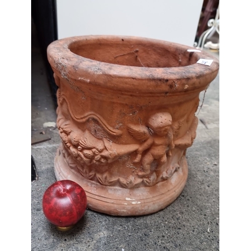 440 - A Large Terracotta Jardinière with Cherub Motif, from the 20th Century, paired with vintage wooden c... 