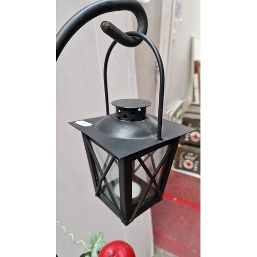 479 - Decorative wrought-iron floor lantern with glass-paneled housing